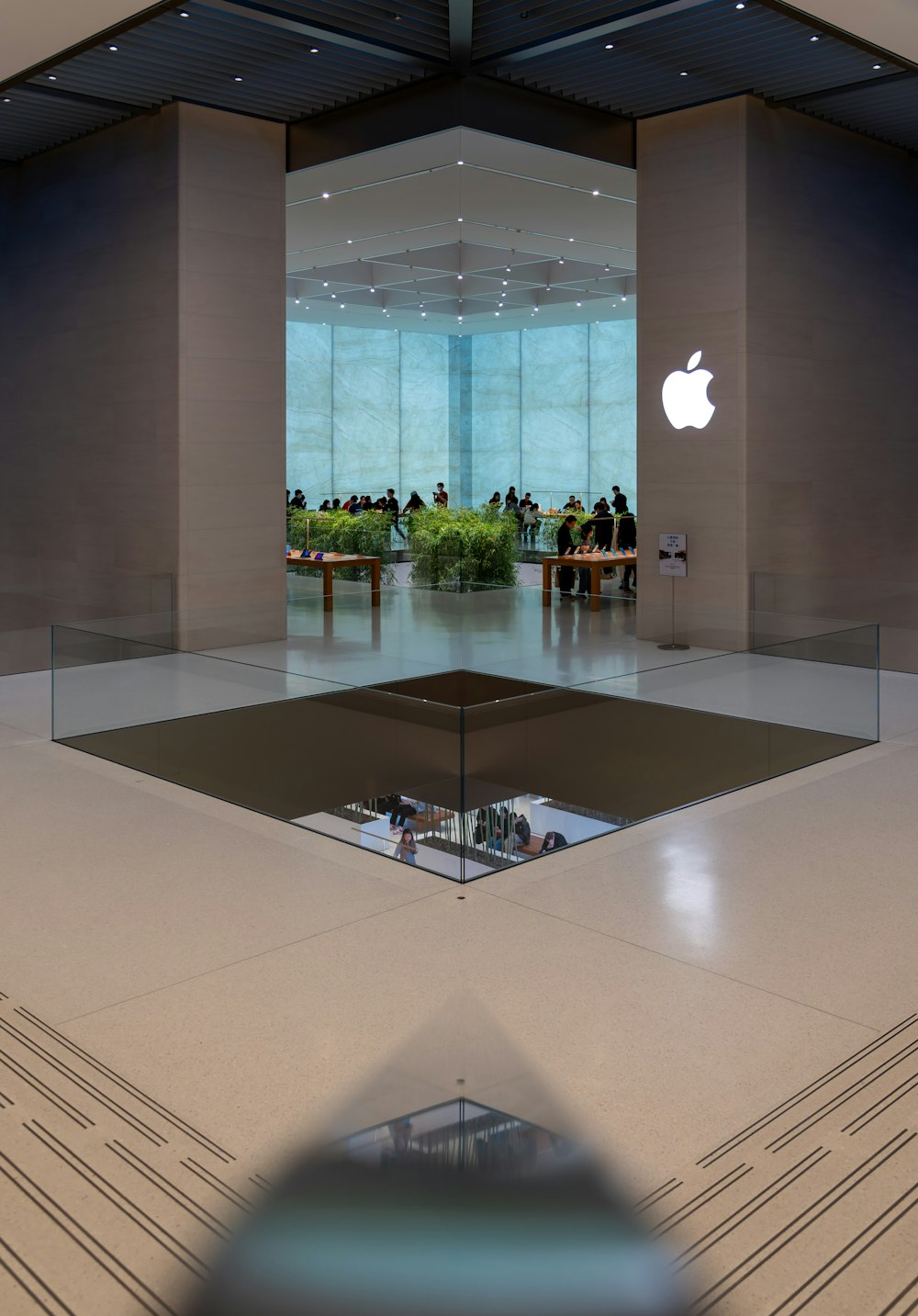 Un Apple Store avec des gens debout à l’arrière-plan