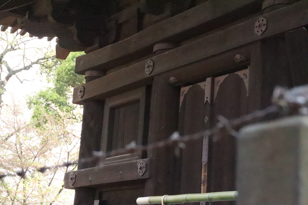 a close up of a wooden building with a chain link fence