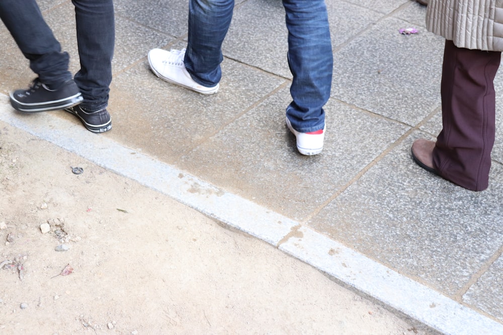 a group of people standing next to each other on a sidewalk
