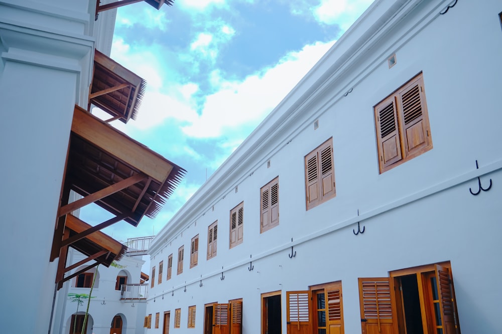 a white building with wooden shutters and windows