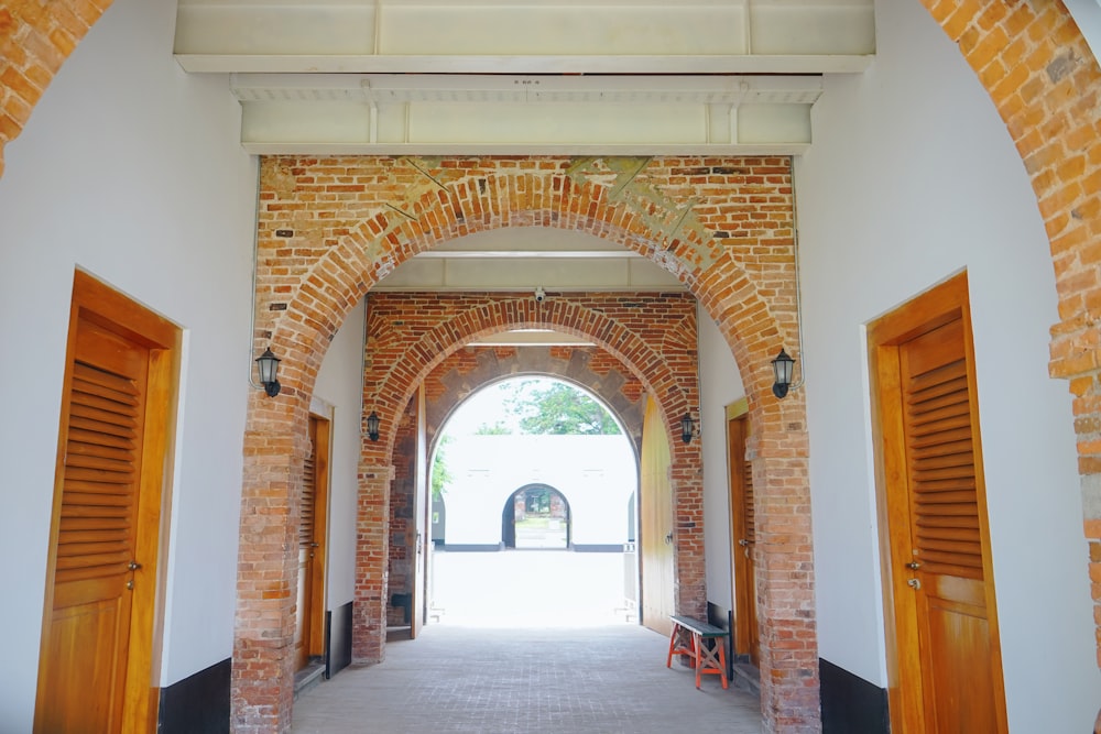 an archway leading into a building with a clock on the wall
