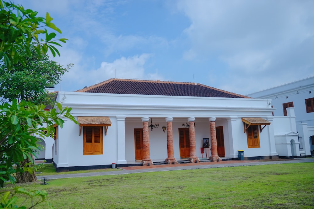 a white building with columns and a red door