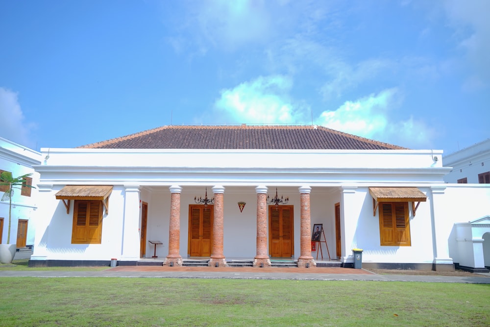 a large white building with columns and wooden doors