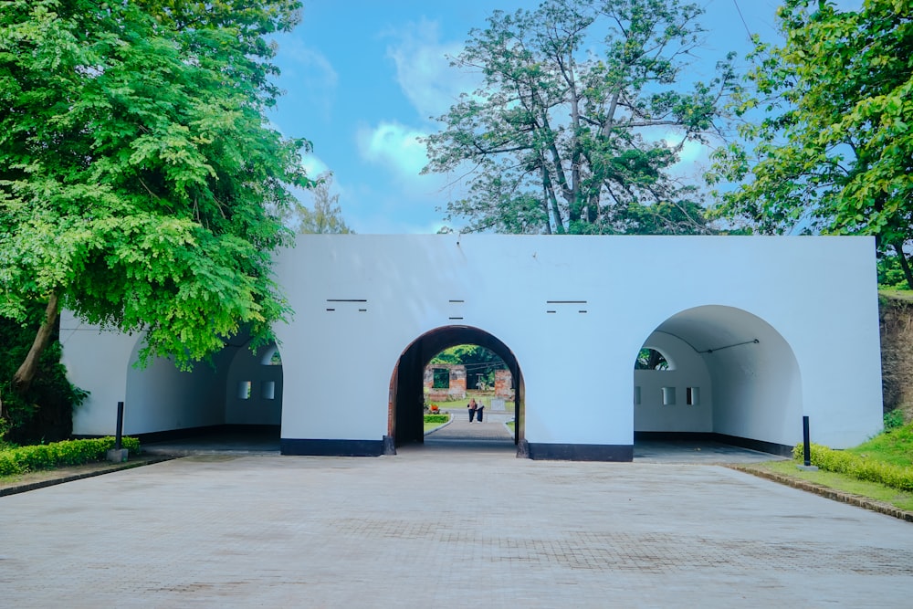 a large white building with a tunnel in the middle of it