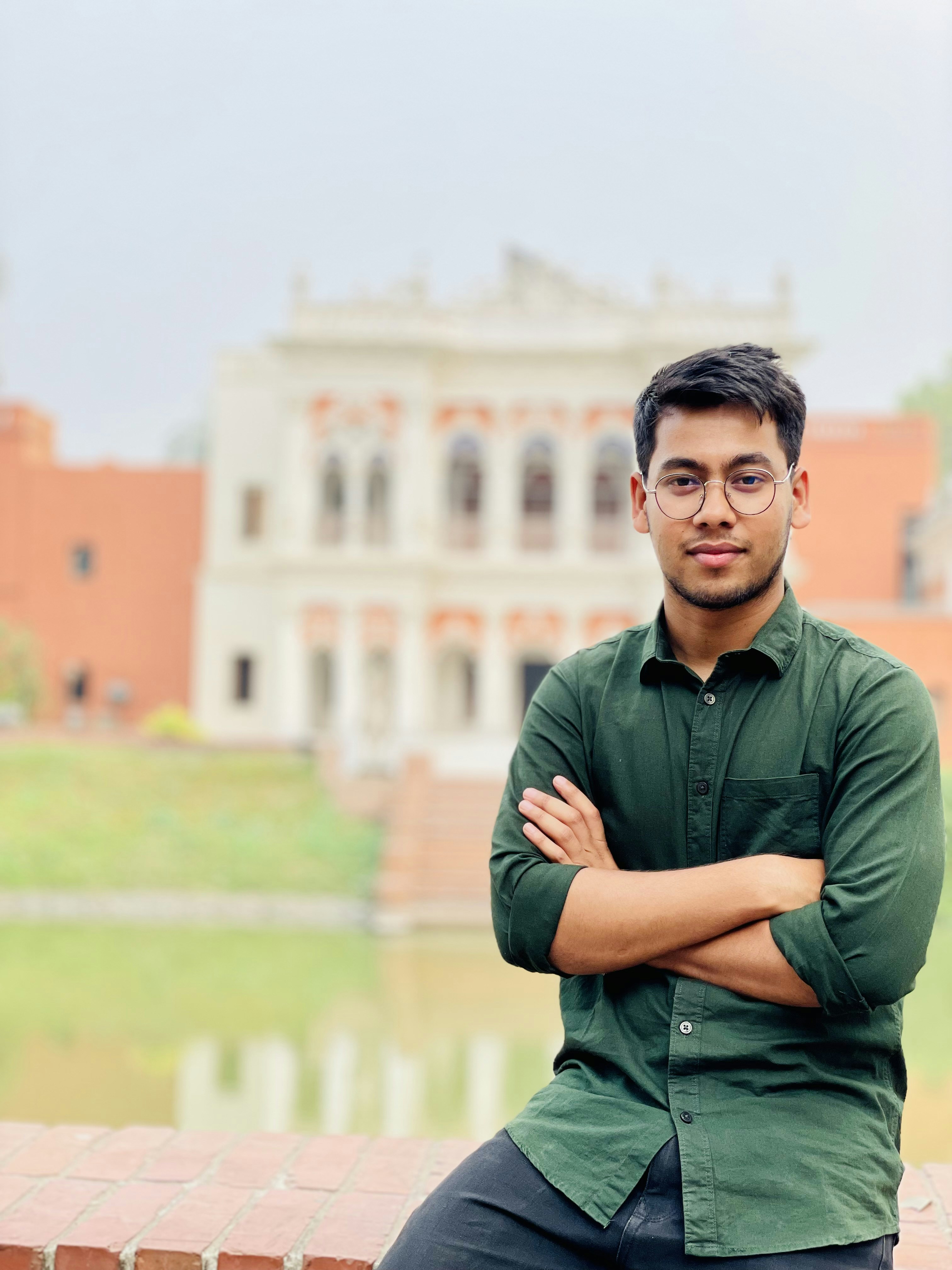a man sitting on a brick wall with his arms crossed