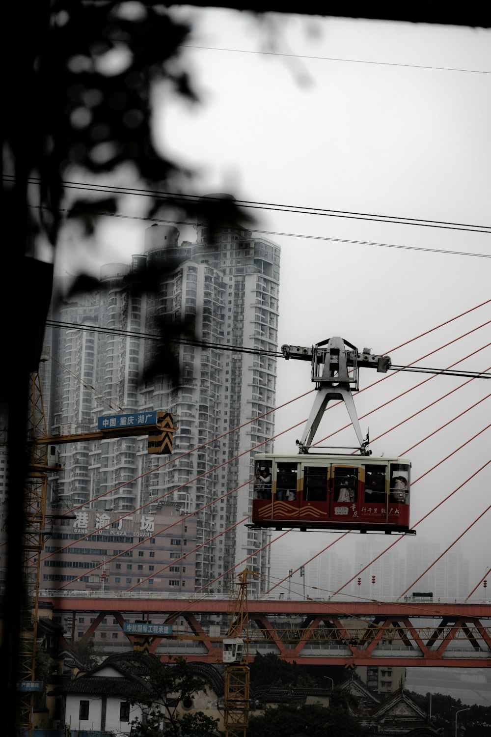 a red cable car going over a bridge