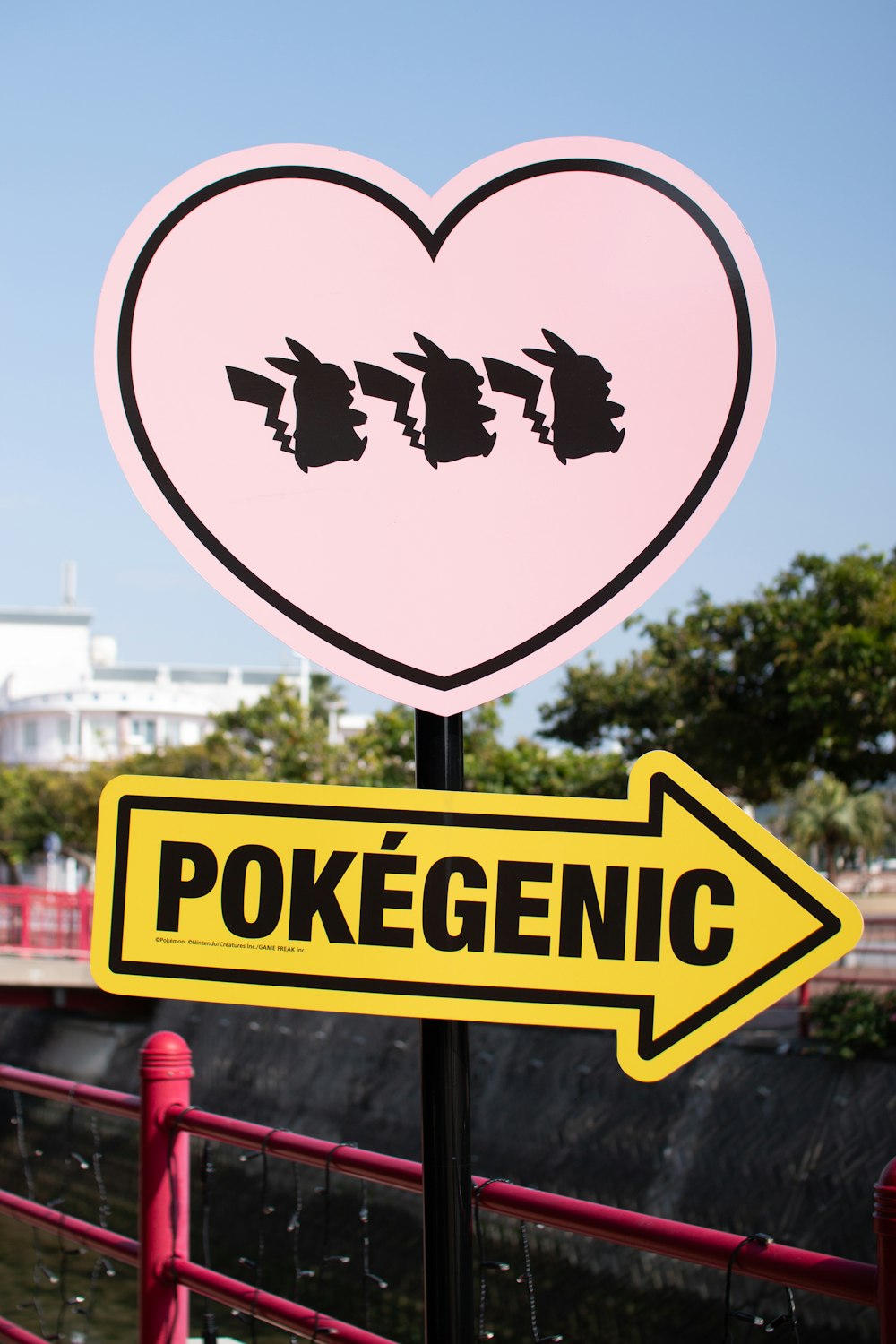 a pink heart shaped sign with a yellow arrow pointing to the right