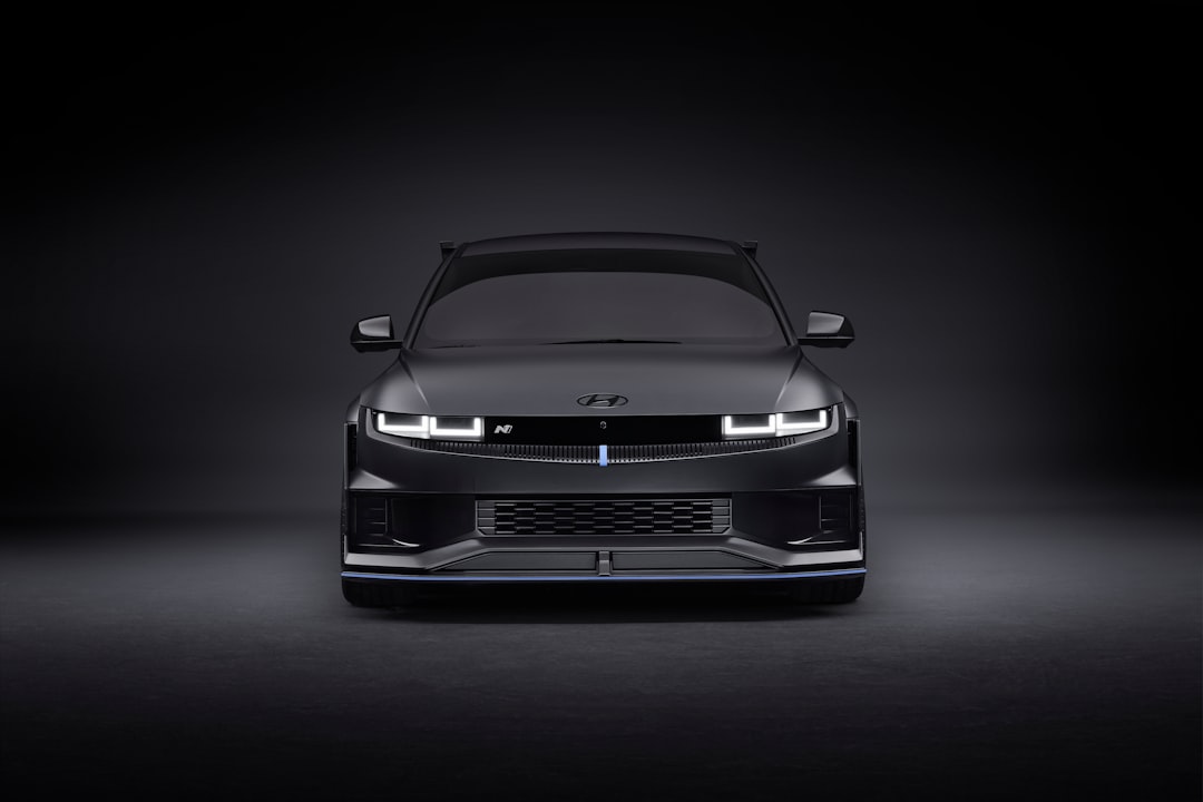the front end of a black car in a dark room, The front view of the Hyundai NPX1 standing under dark studio lights.