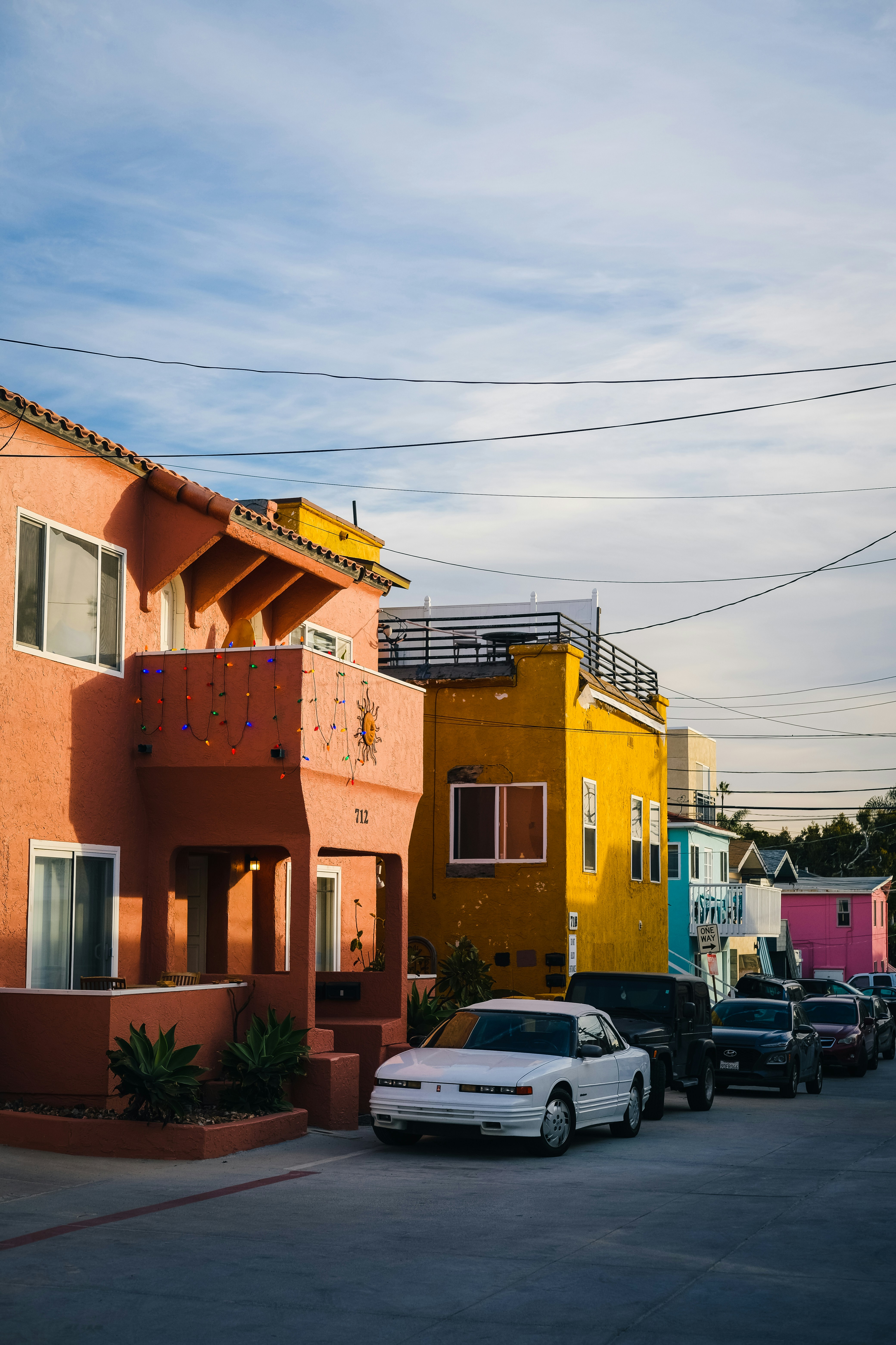 a row of houses with cars parked in front of them