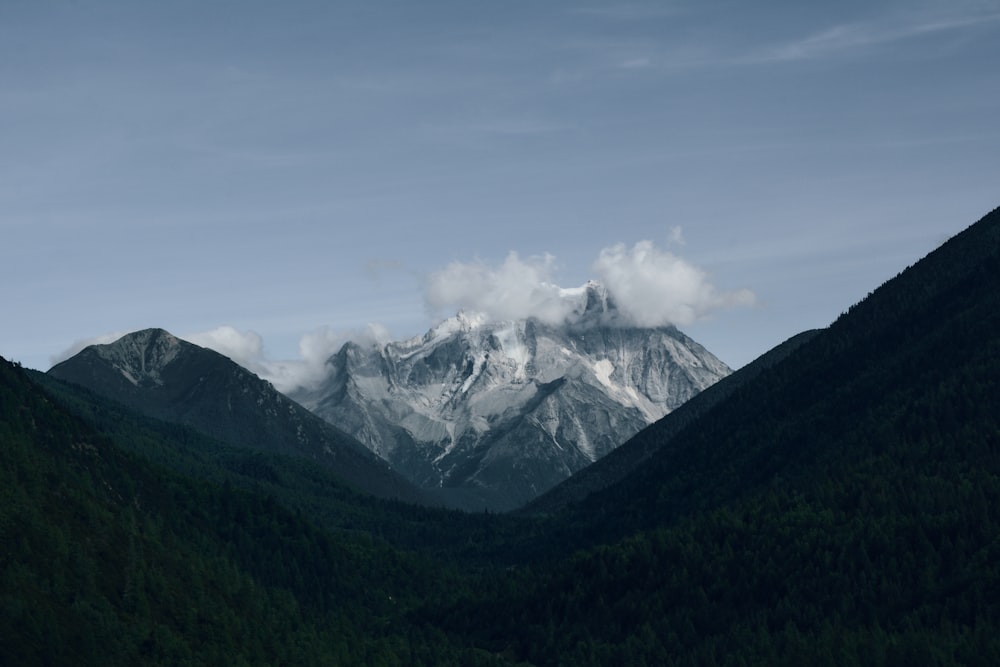 a mountain range covered in snow and clouds