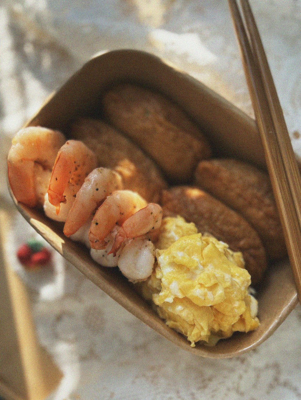 a close up of a tray of food with chopsticks
