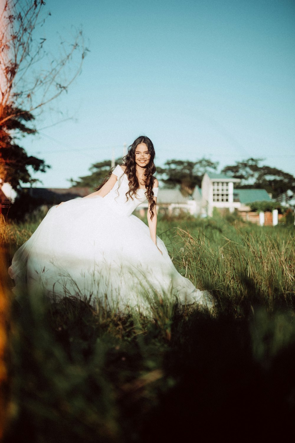 a woman in a white dress standing in a field