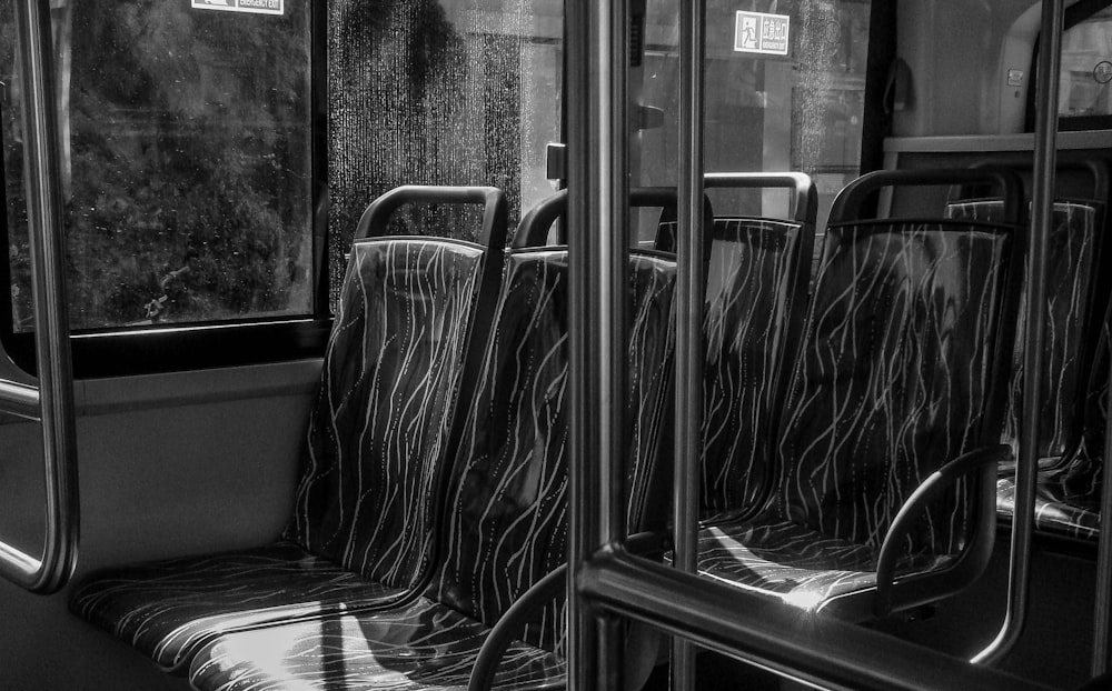 a black and white photo of empty seats on a bus