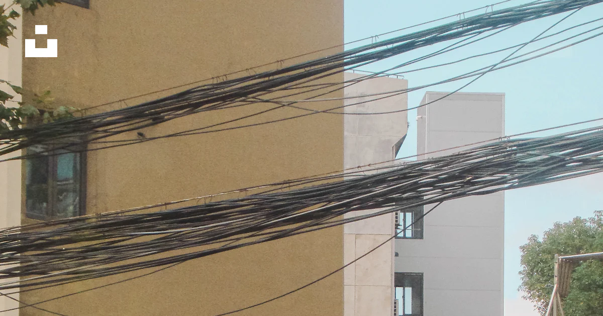 A couple of buildings that have power lines above them photo – Free ...