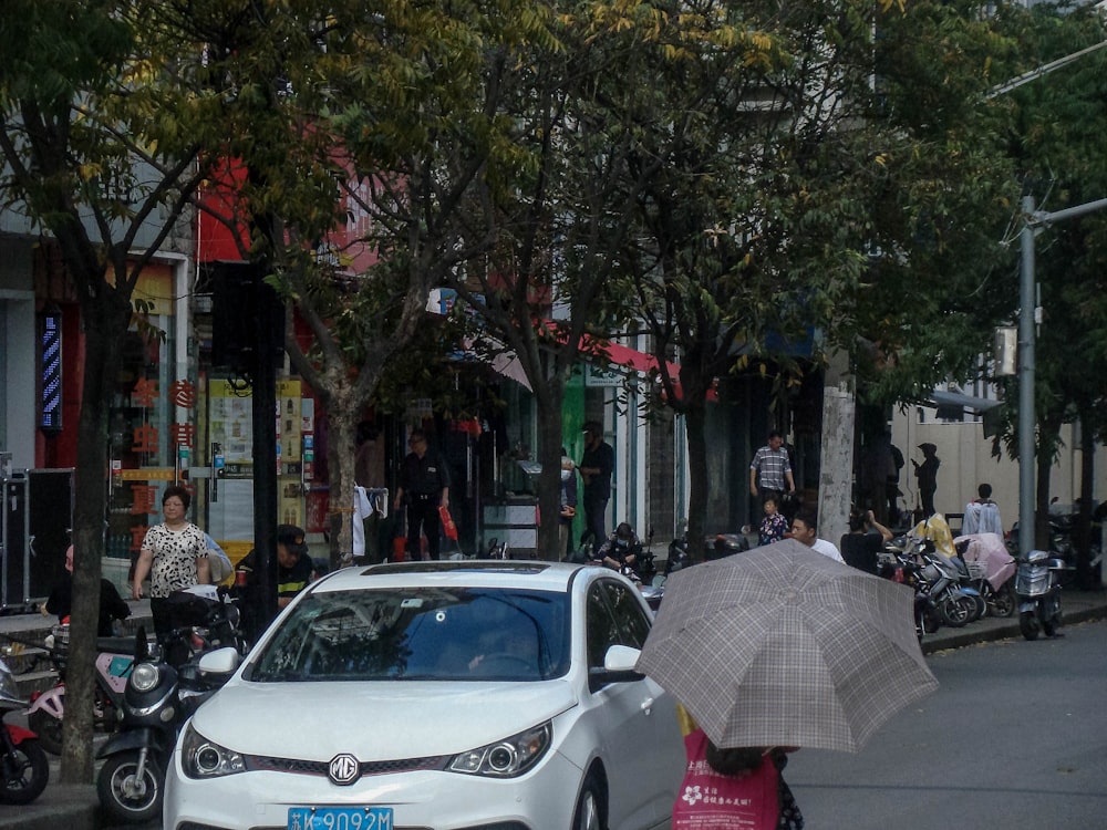 a woman with an umbrella walks down the street