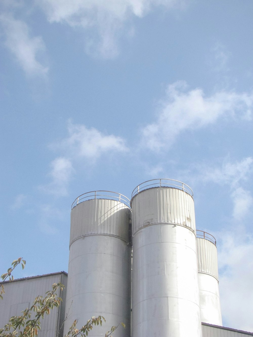 two silos against a blue sky with clouds