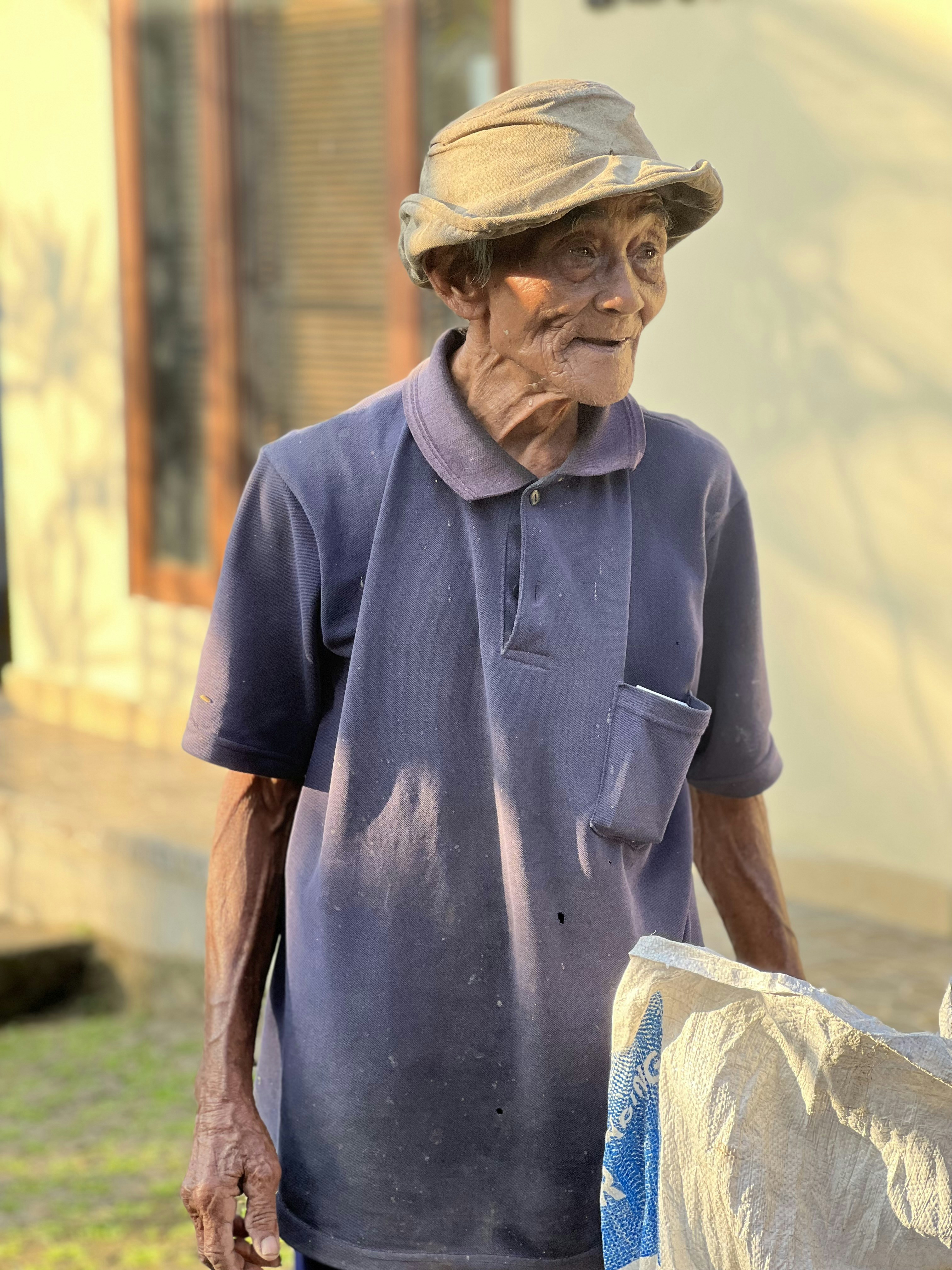 an old man wearing a hat and a blue shirt