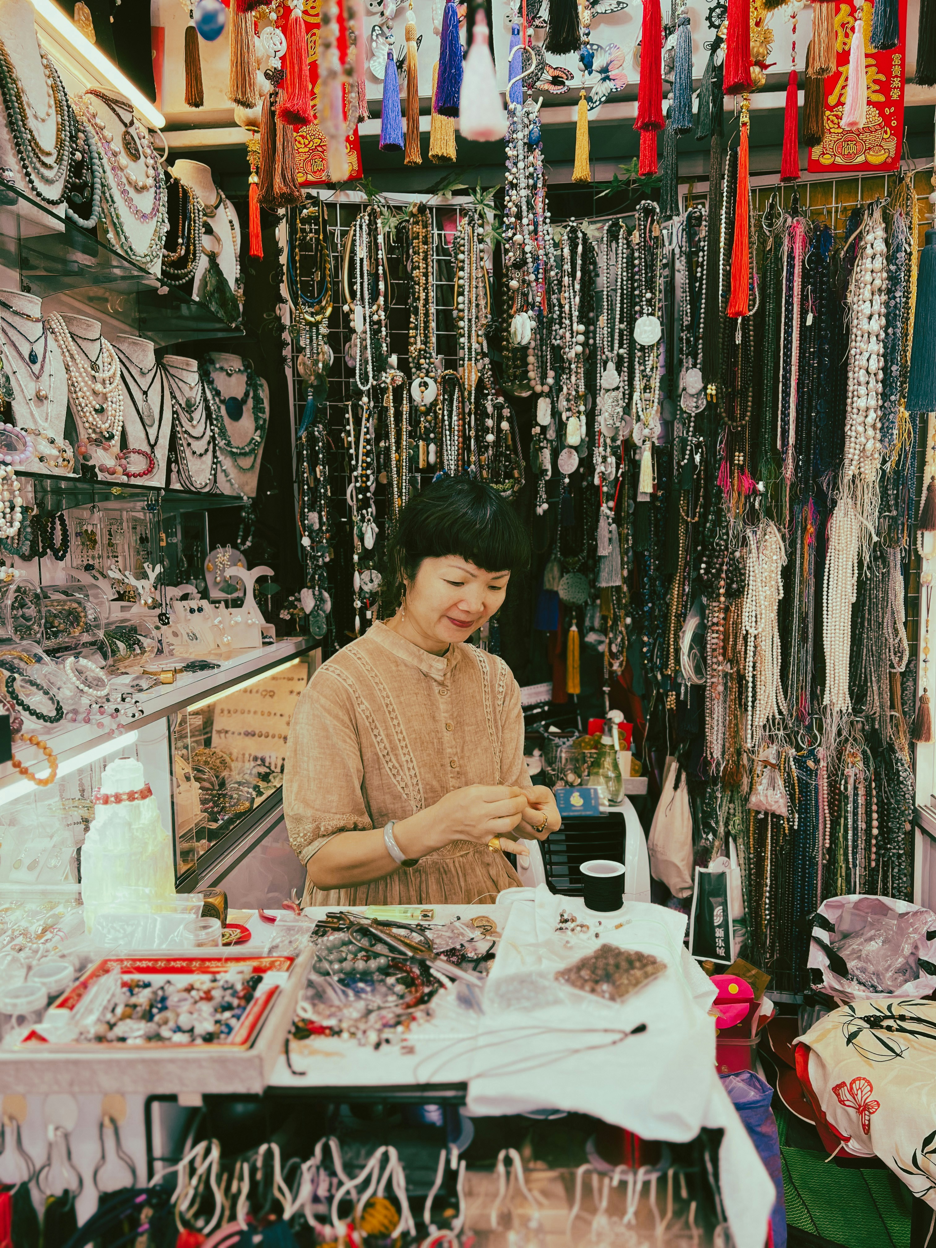 a woman standing in front of a display of jewelry