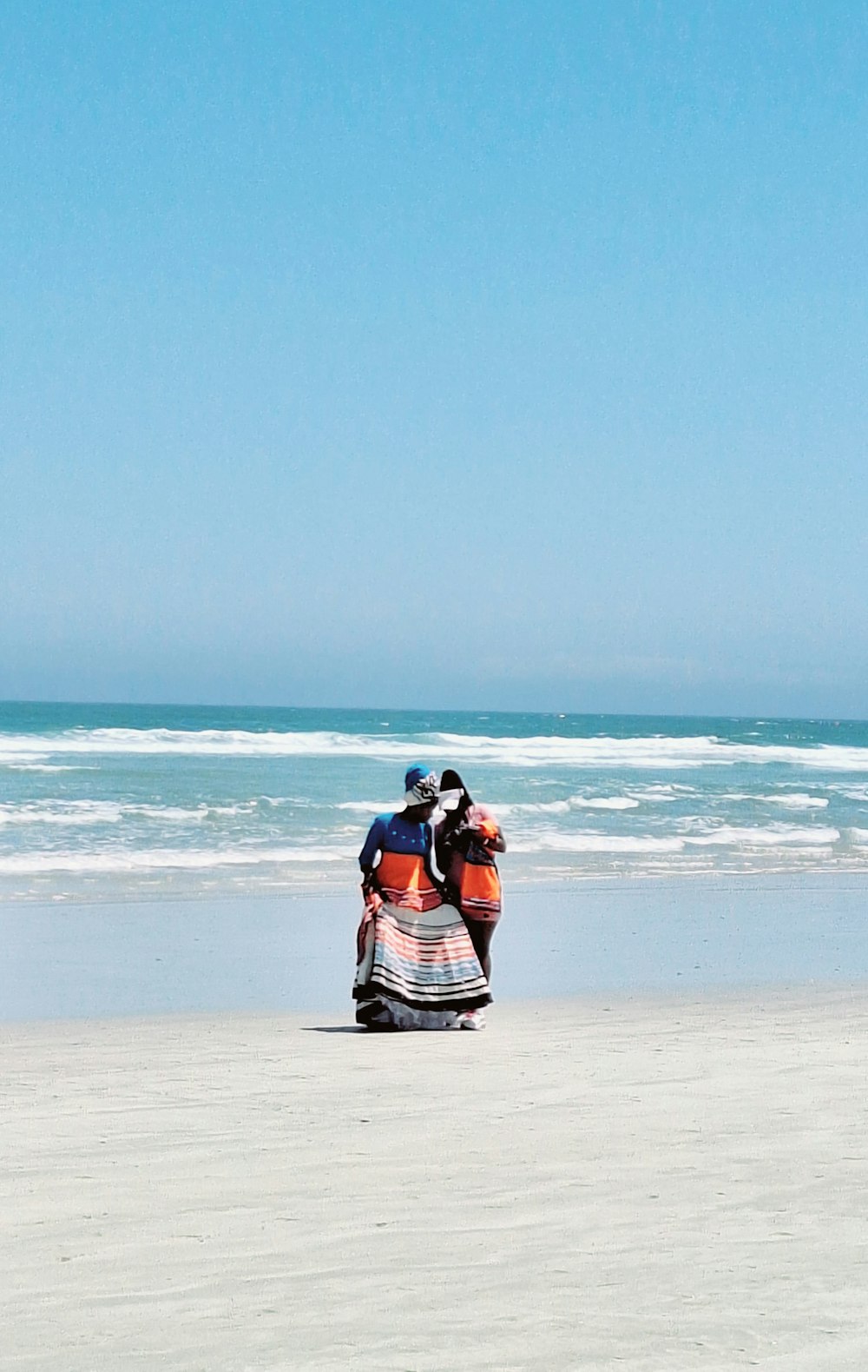 two people riding a motorcycle on the beach