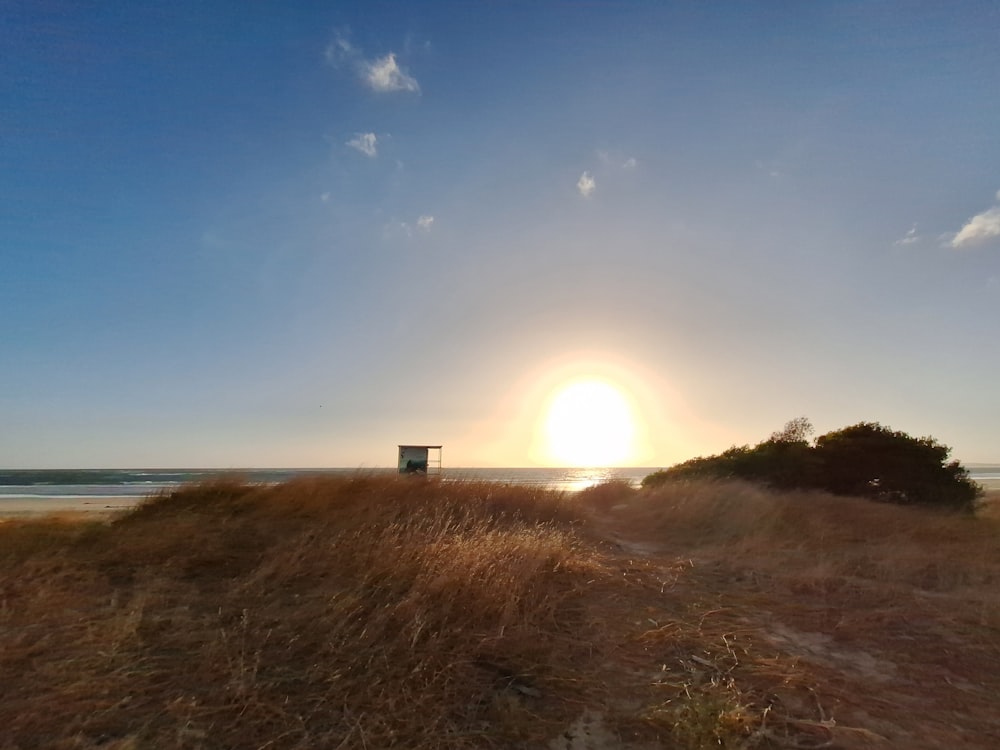 the sun is setting over the beach and the water