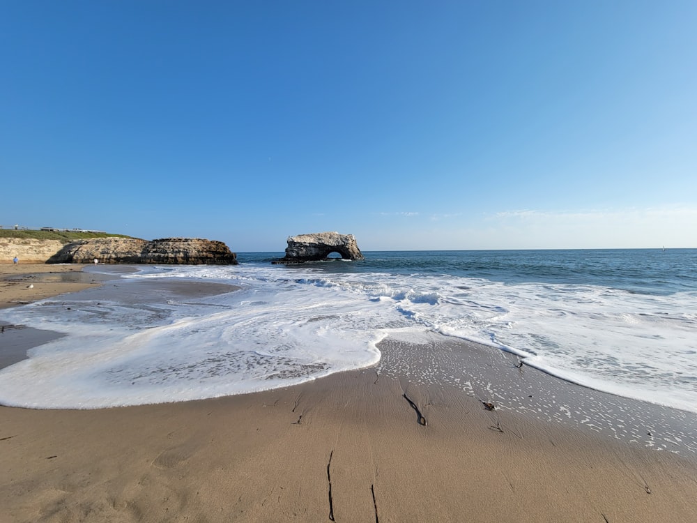 a sandy beach with waves coming in to shore