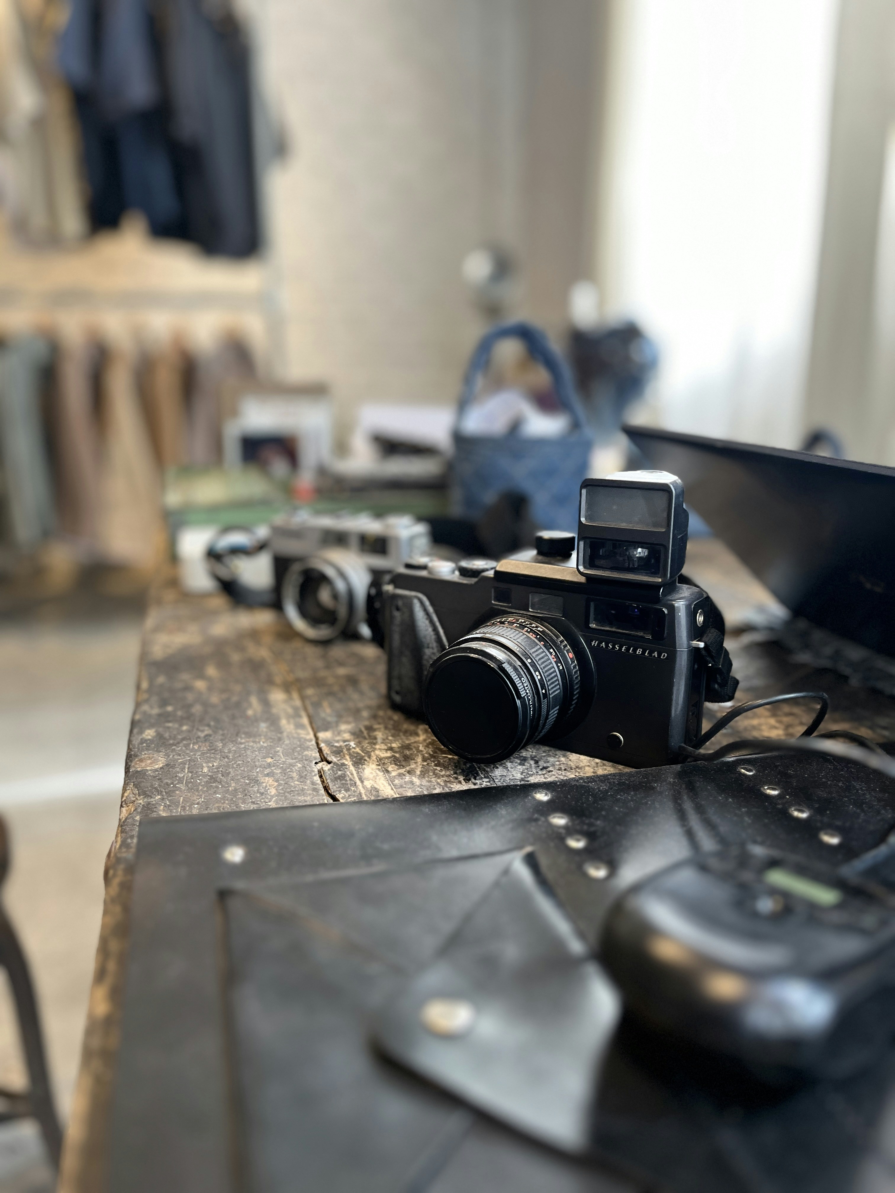 Vintage camera collection on dark wooden table, moody atmospheric lighting, collector auction display