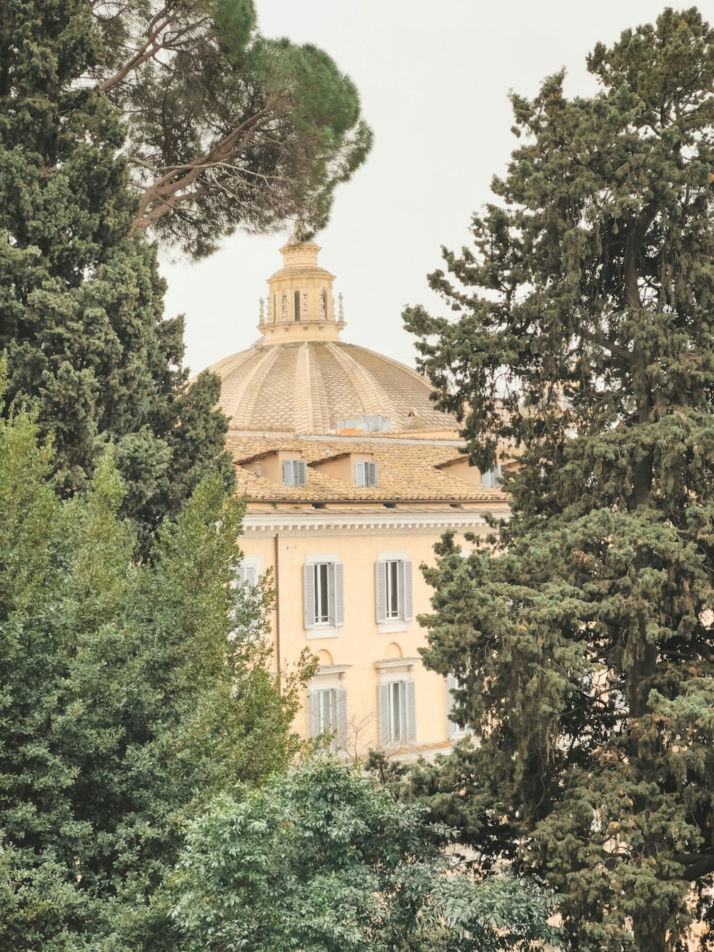 a yellow building surrounded by trees and bushes