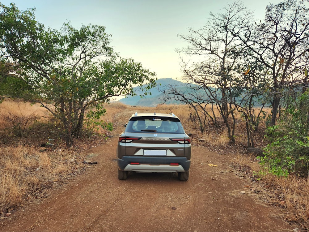 um carro estacionado à beira de uma estrada de terra