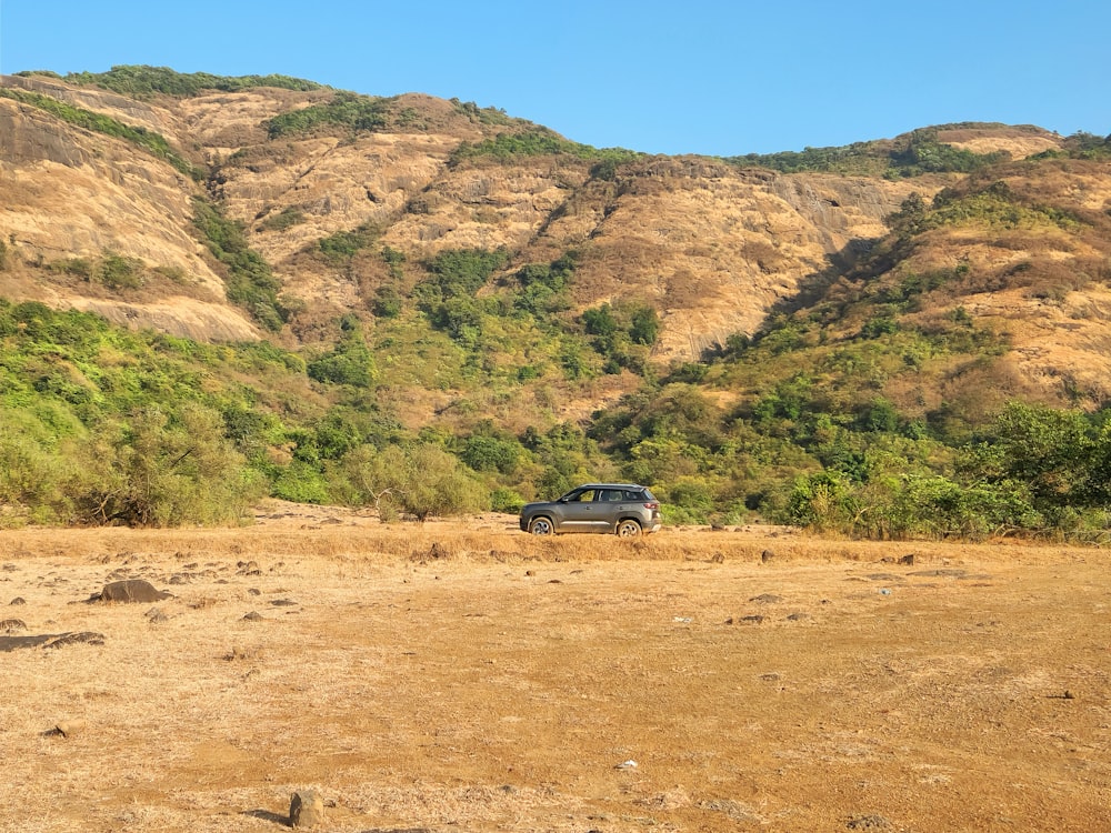 a car parked in the middle of a dirt field