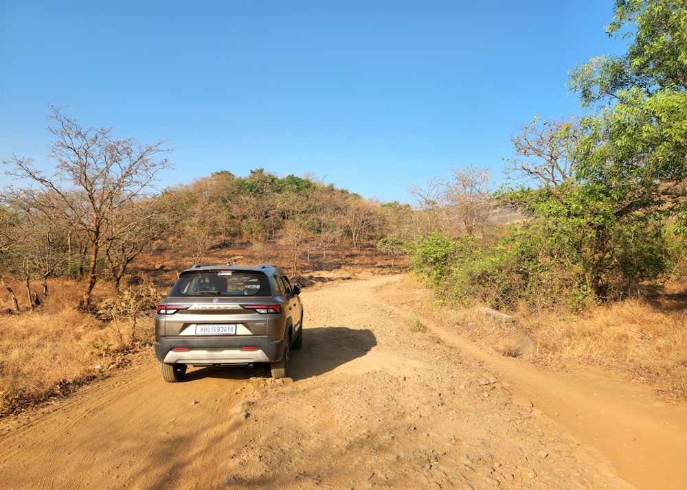 um carro está dirigindo por uma estrada de terra