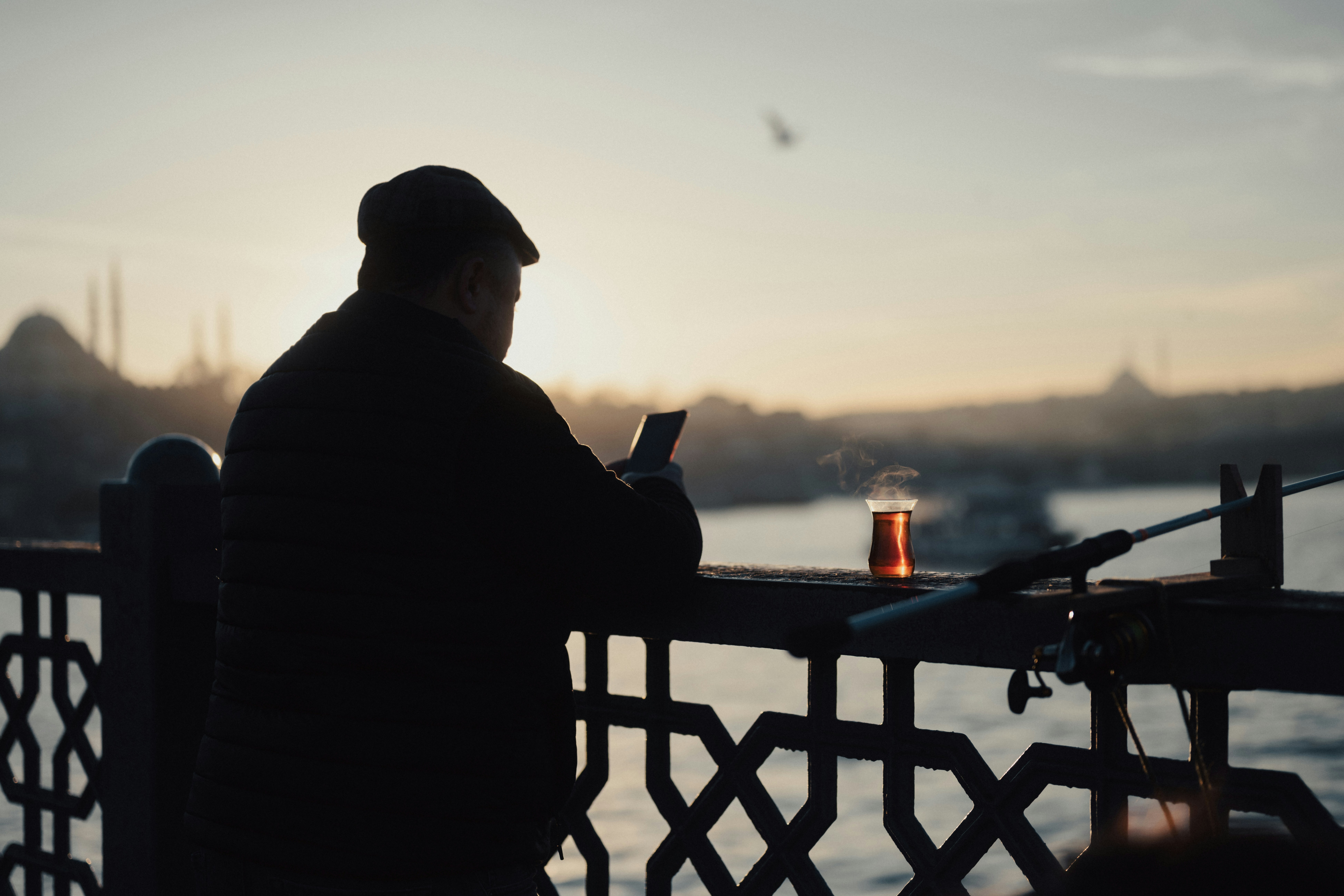 a man sitting on a bench looking at his cell phone