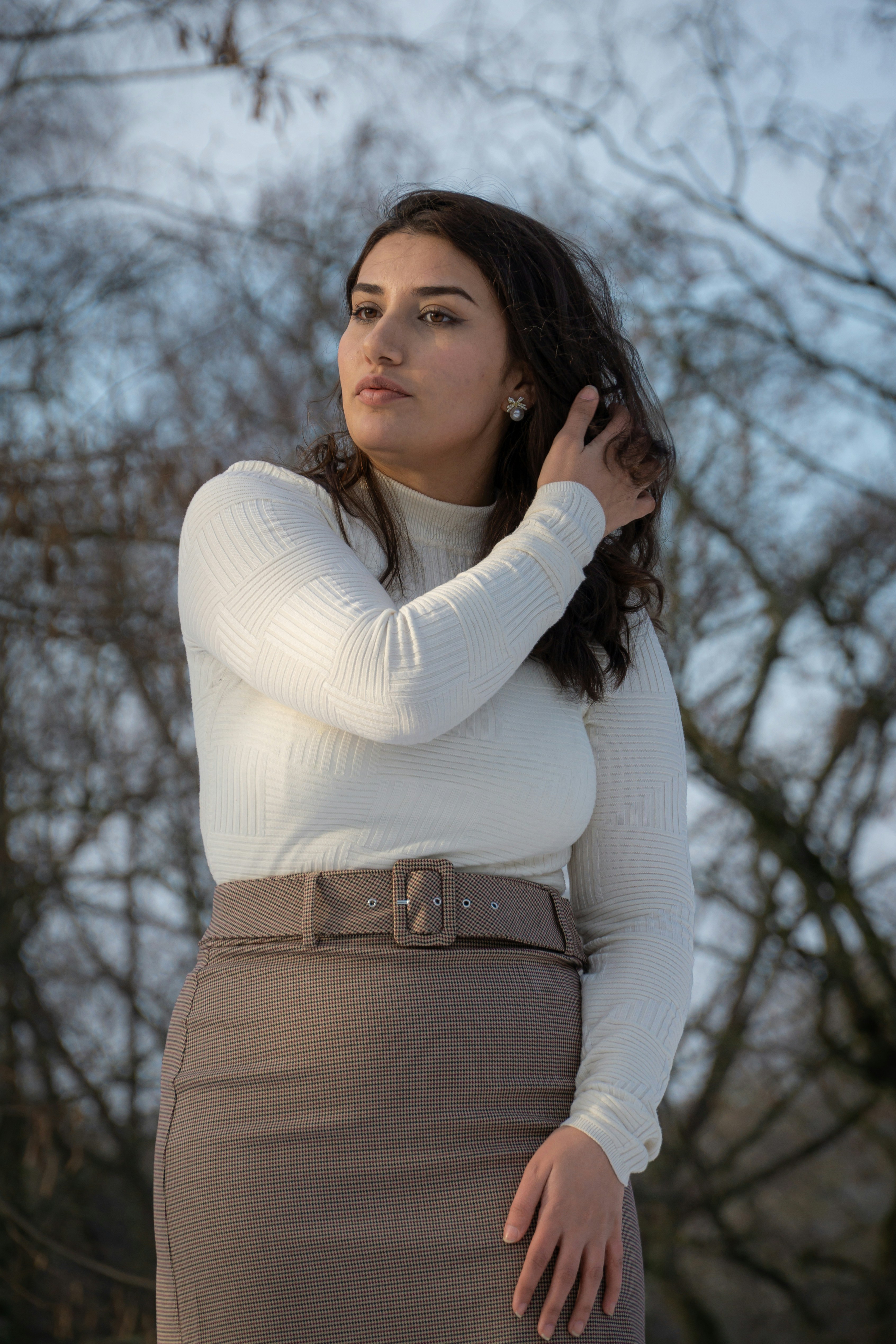 흰 스웨터와 갈색 치마를 입은 여자