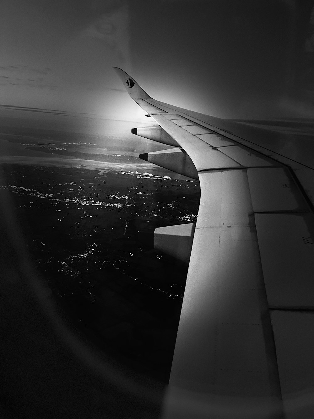 the wing of an airplane flying over a city