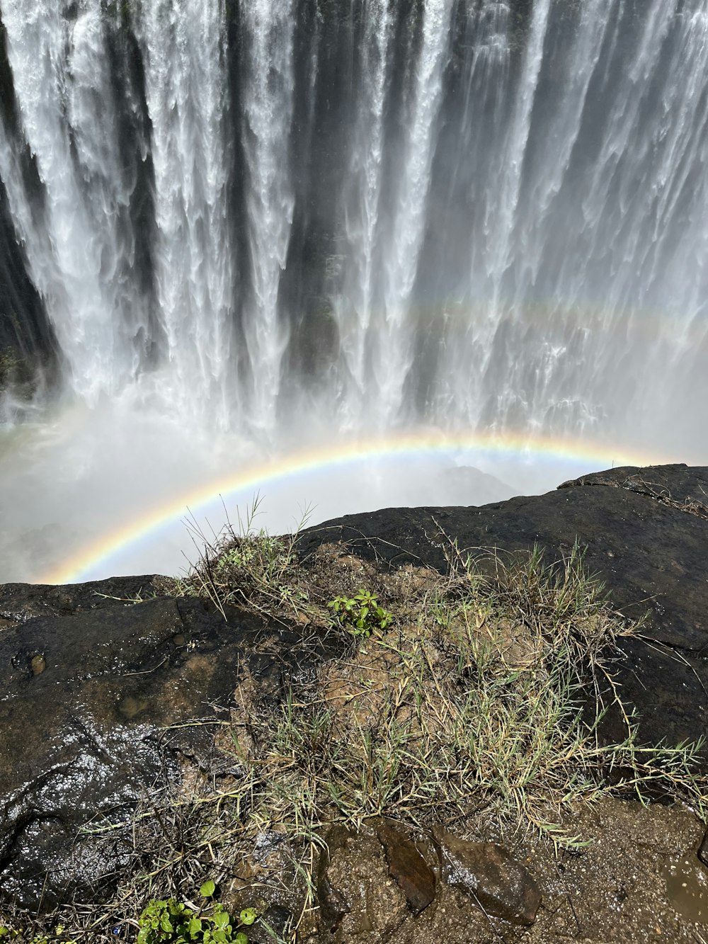 a rainbow in the sky over a waterfall