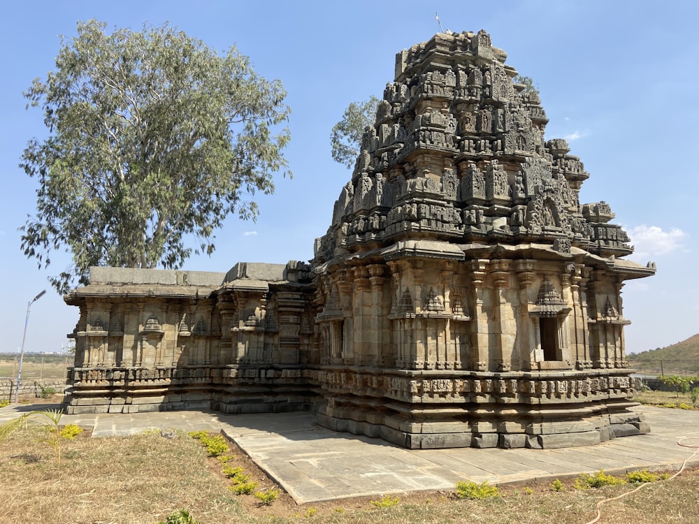 a large stone structure with a tree in the background