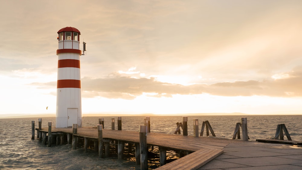 a red and white light house sitting on top of a pier