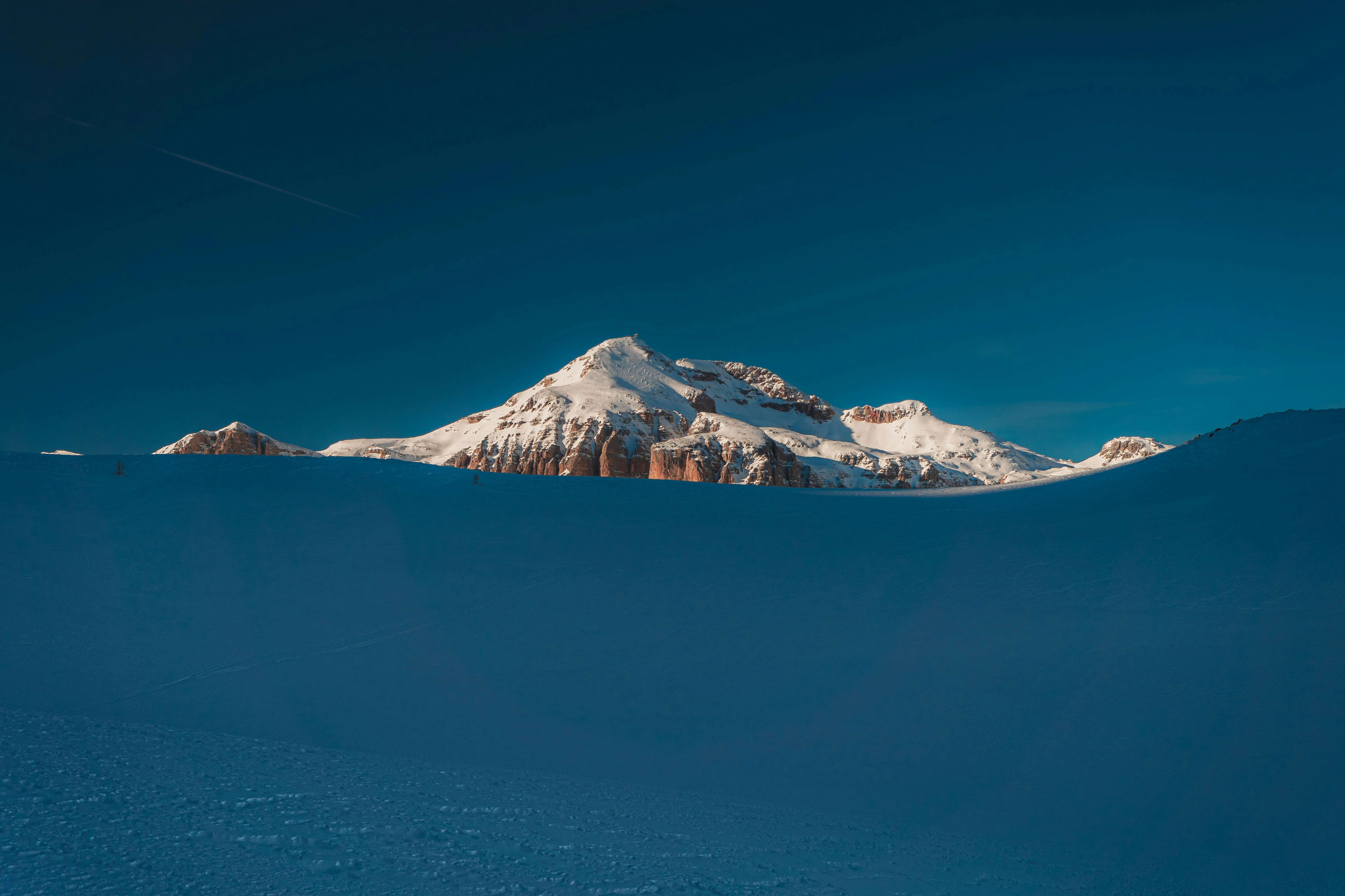 a mountain covered in snow under a blue sky