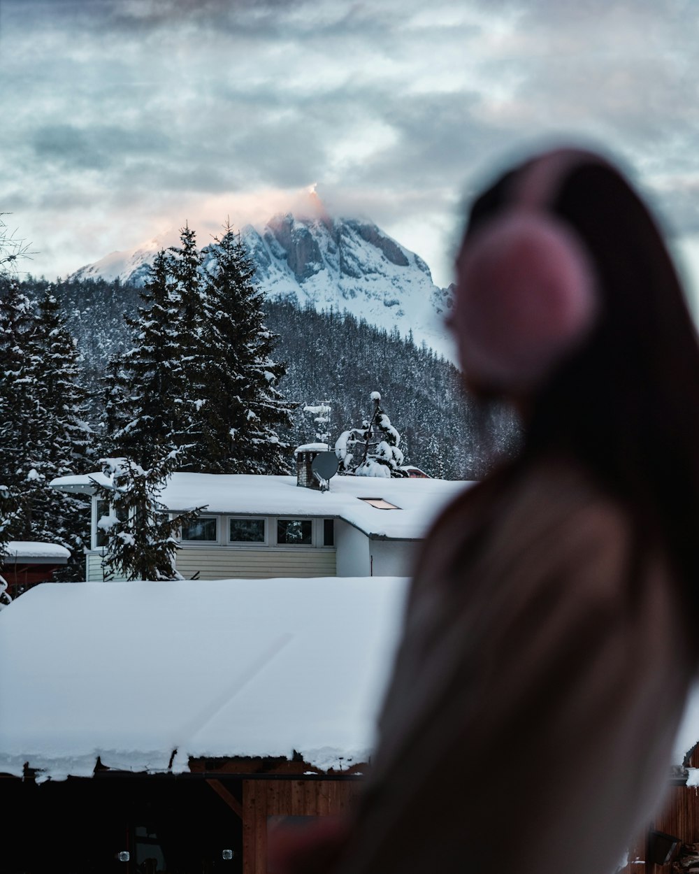 a view of a snow covered mountain with a house in the foreground