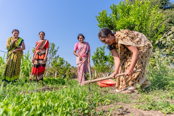 a group of women standing next to each other in a field