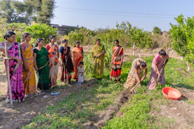 a group of women standing next to each other in a field