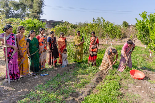 a group of women standing next to each other in a field