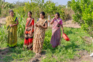 a group of women standing next to each other in a field