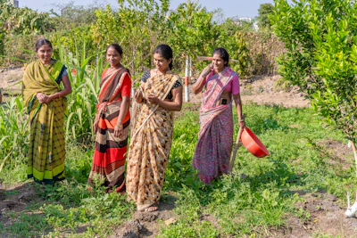 a group of women standing next to each other in a field