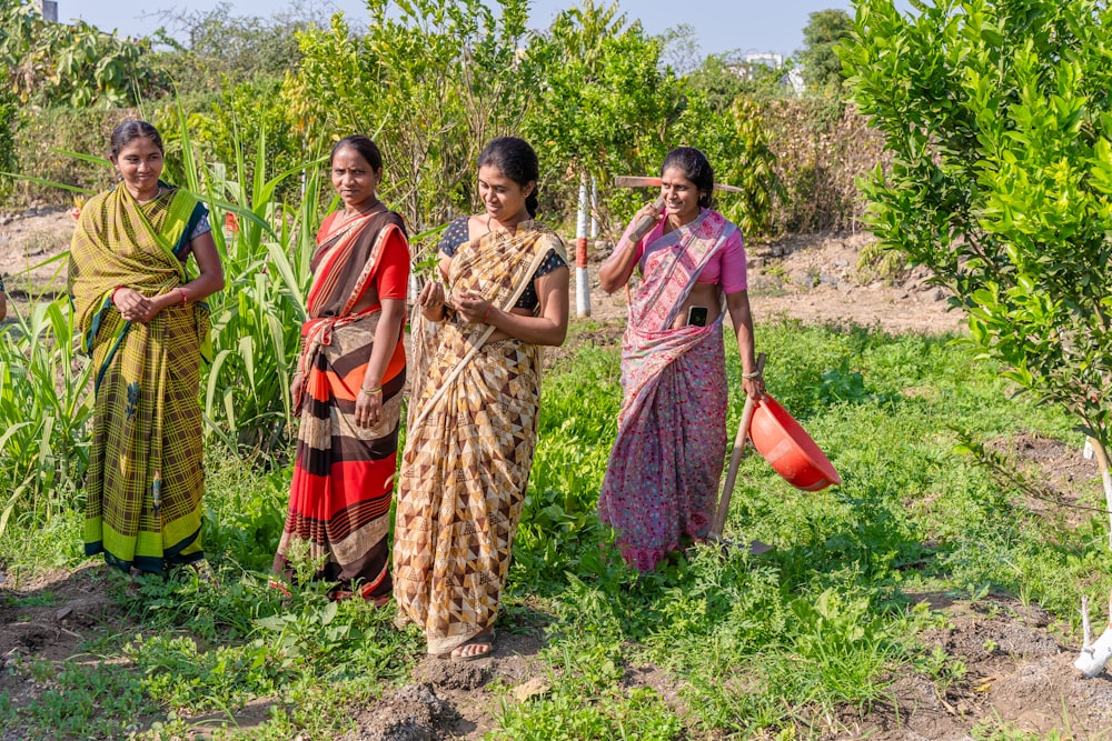 a group of women standing next to each other in a field