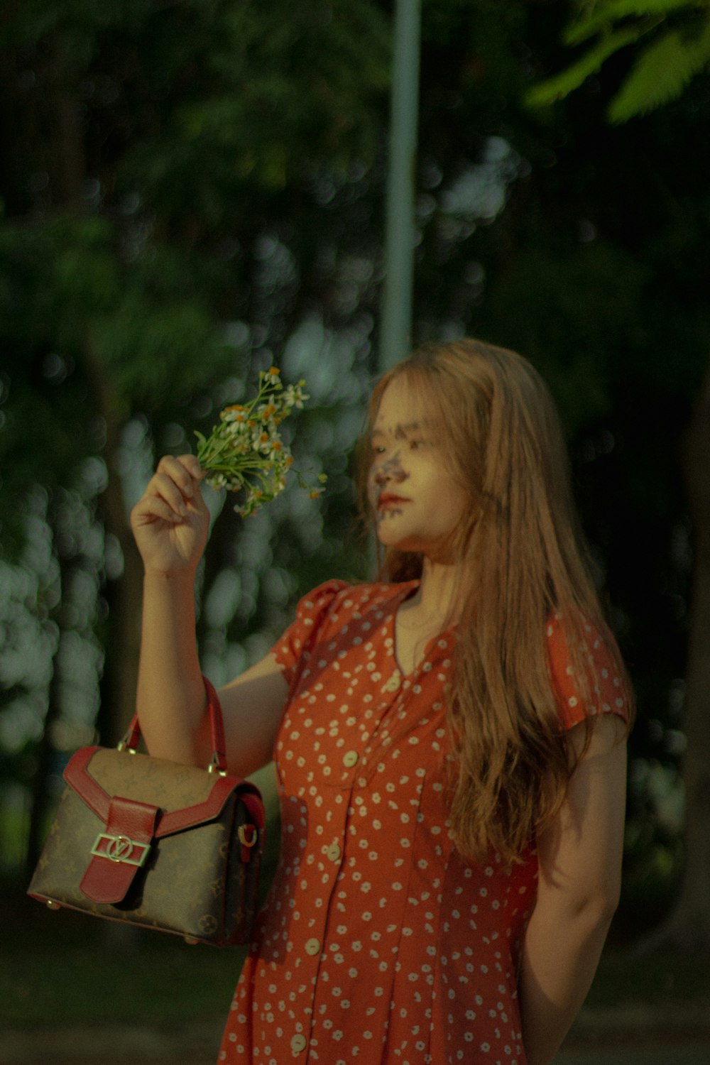 a woman in a red dress holding a small plant