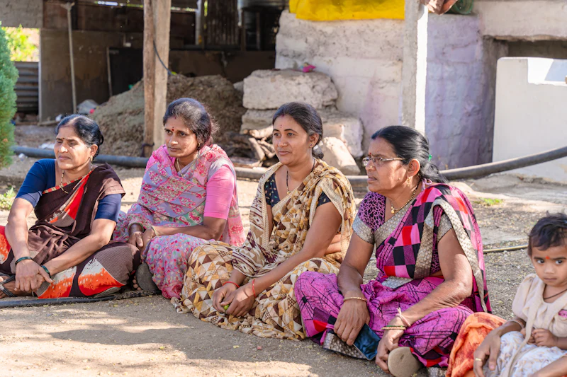 Women seated together outside a village home