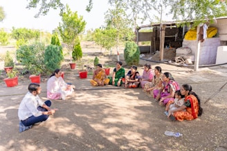 a group of women sitting on the ground in a circle