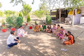 a group of women sitting on the ground in a circle