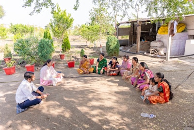 a group of women sitting on the ground in a circle