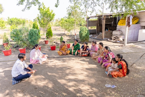 a group of women sitting on the ground in a circle